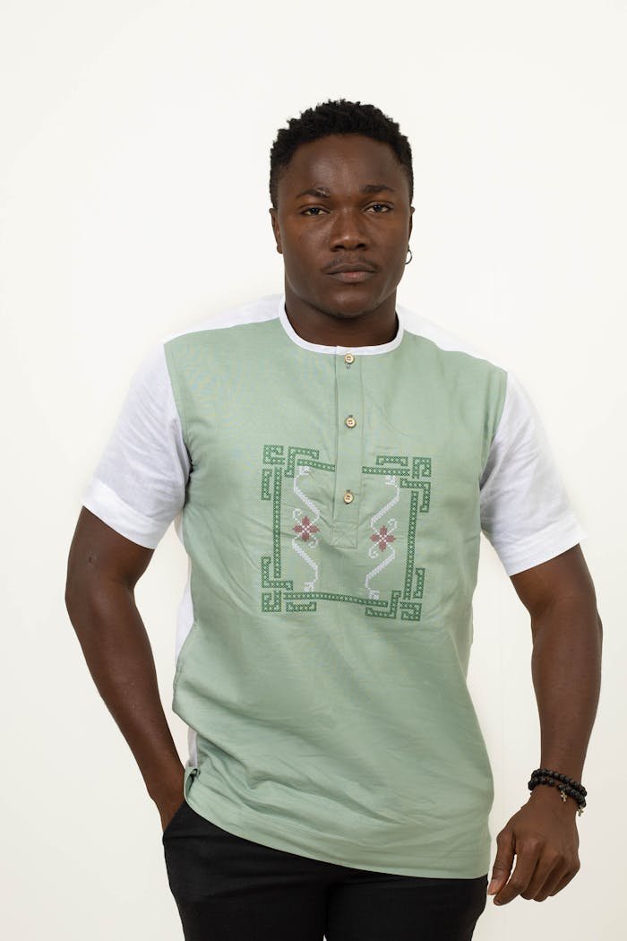 Elegant portrait of a man in a stylish ethnic t-shirt against a neutral background.